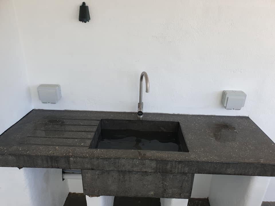 Dark polished concrete outdoor sink and drainer