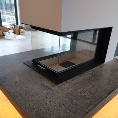 Cast concrete hearth with three‑sided glass fire